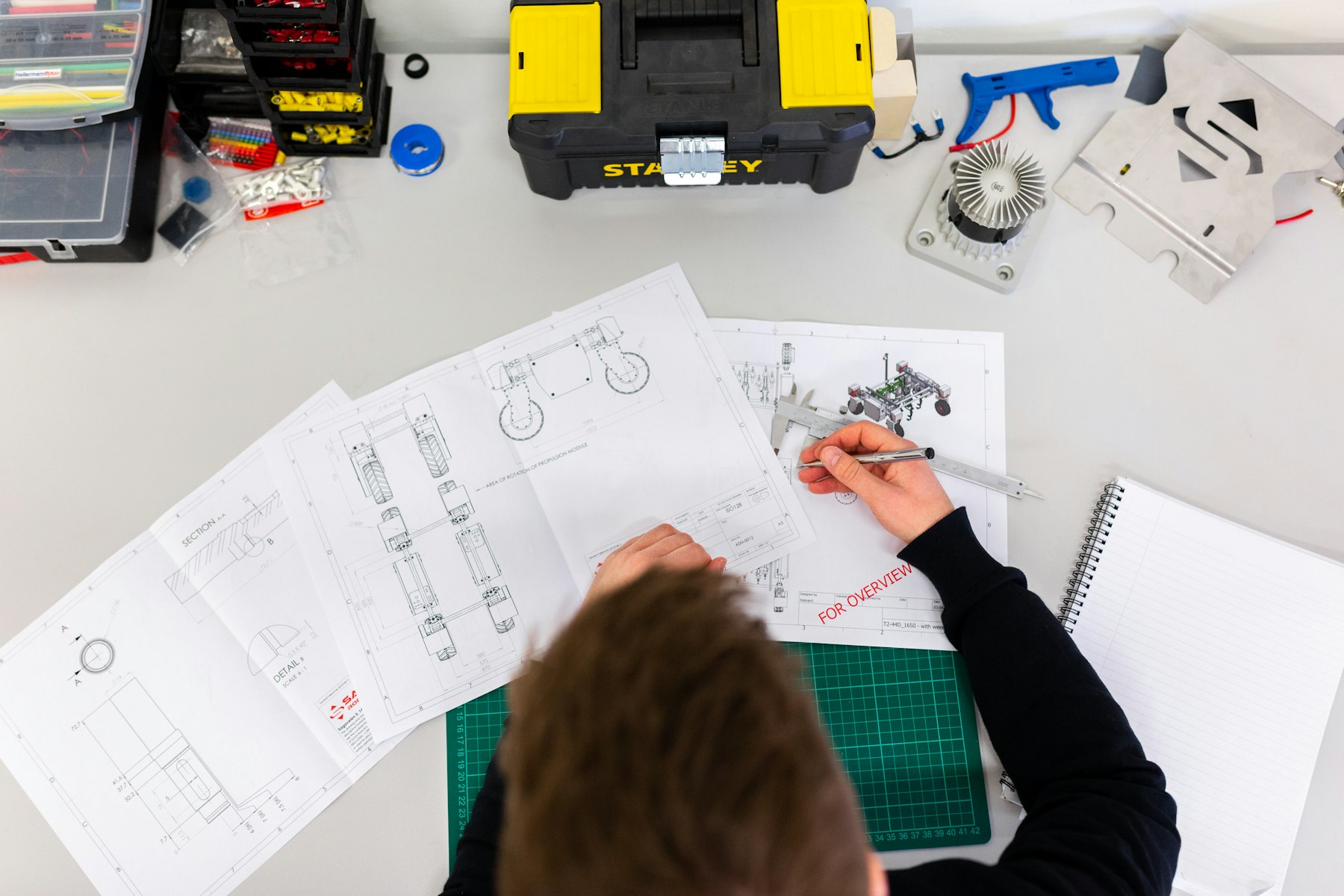 Engineering drawings, specifications, and measurement tools on a workbench